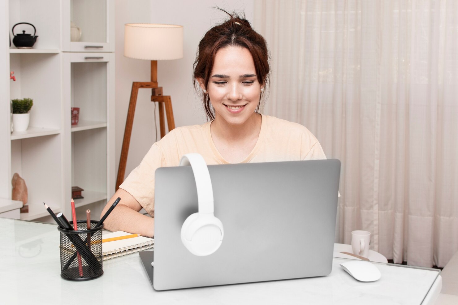 A women sitting on desk and taking online classes