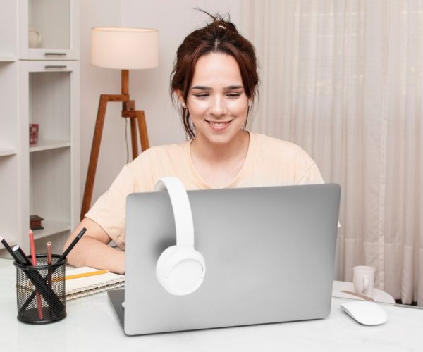A women sitting on desk and taking online classes