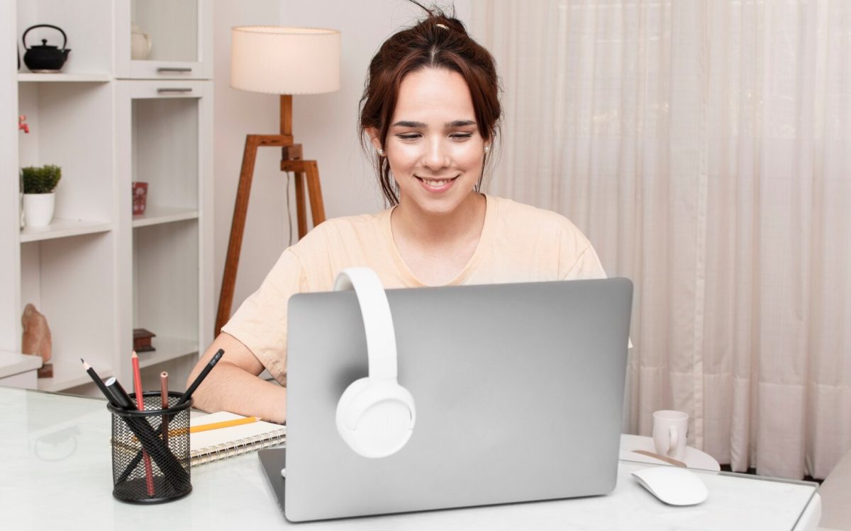 A women sitting on desk and taking online classes